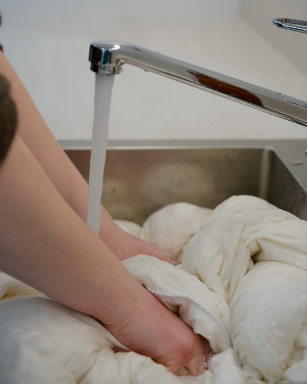 A down duvet getting soaked in a sink