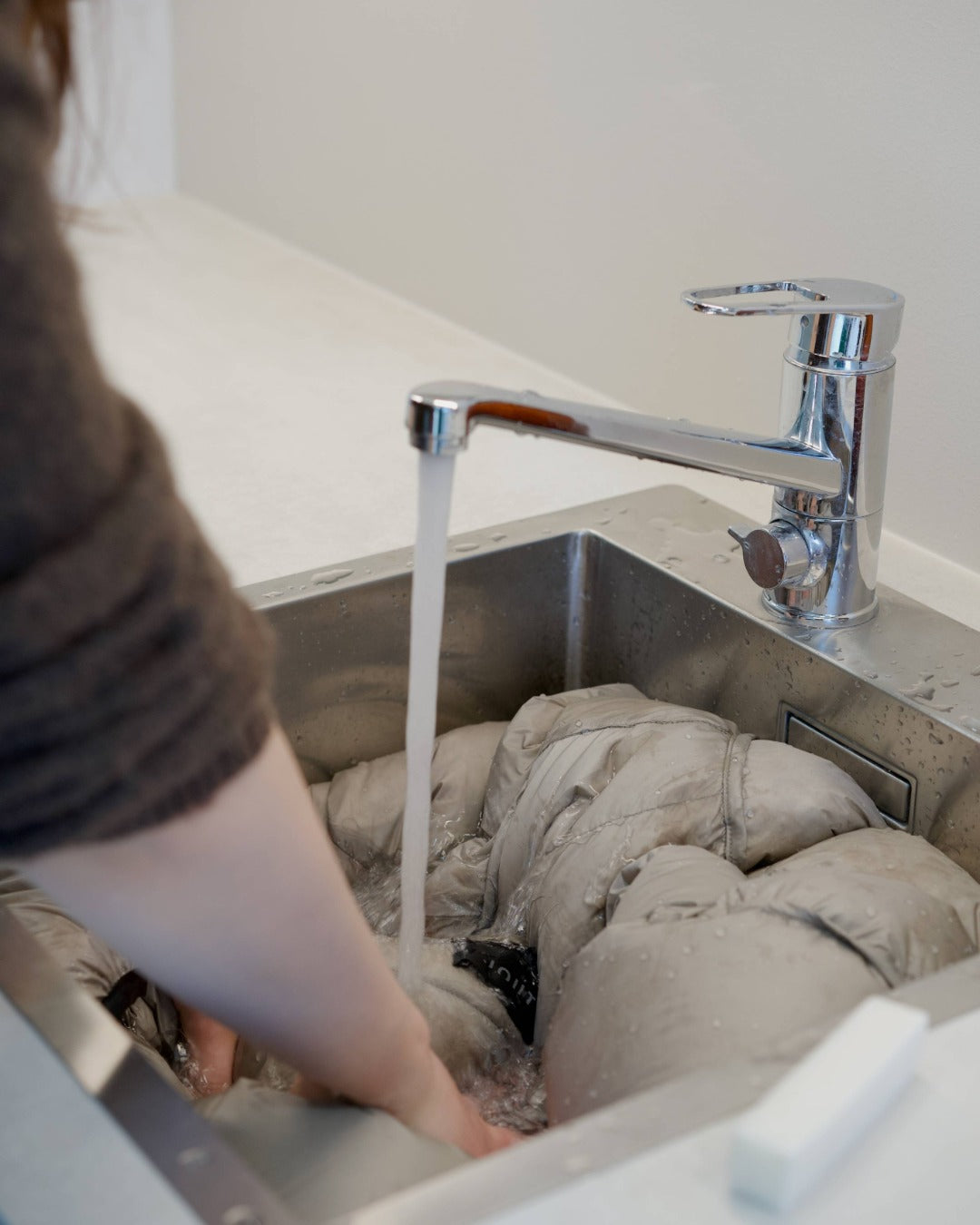 Down coat getting soaked in a sink