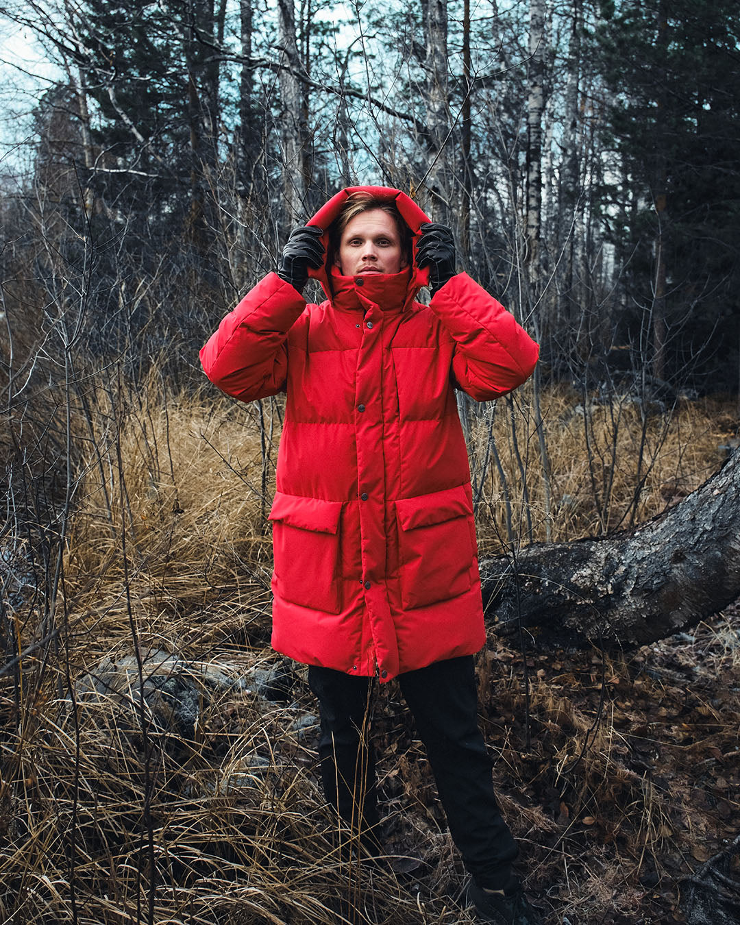 Person wearing a red down coat in a forest setting