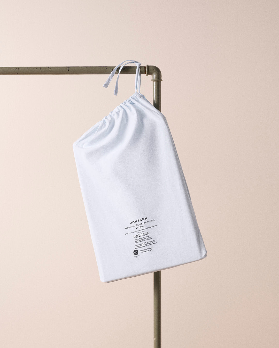 White drawstring bag with text on a beige background